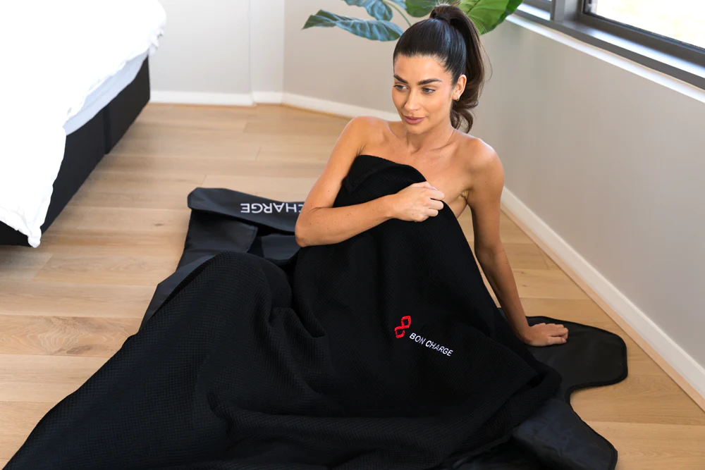 Woman relaxing in Bon Charge sauna blanket during aromatherapy infrared sauna session