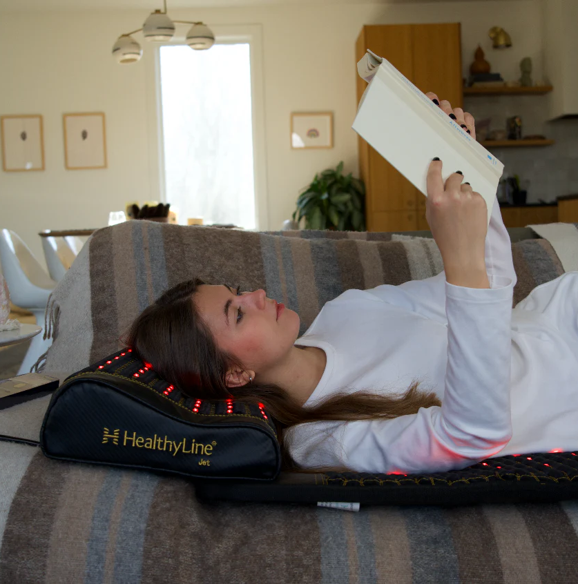 Woman lying on a sofa, her head resting on a HealthyLine Jet pillow