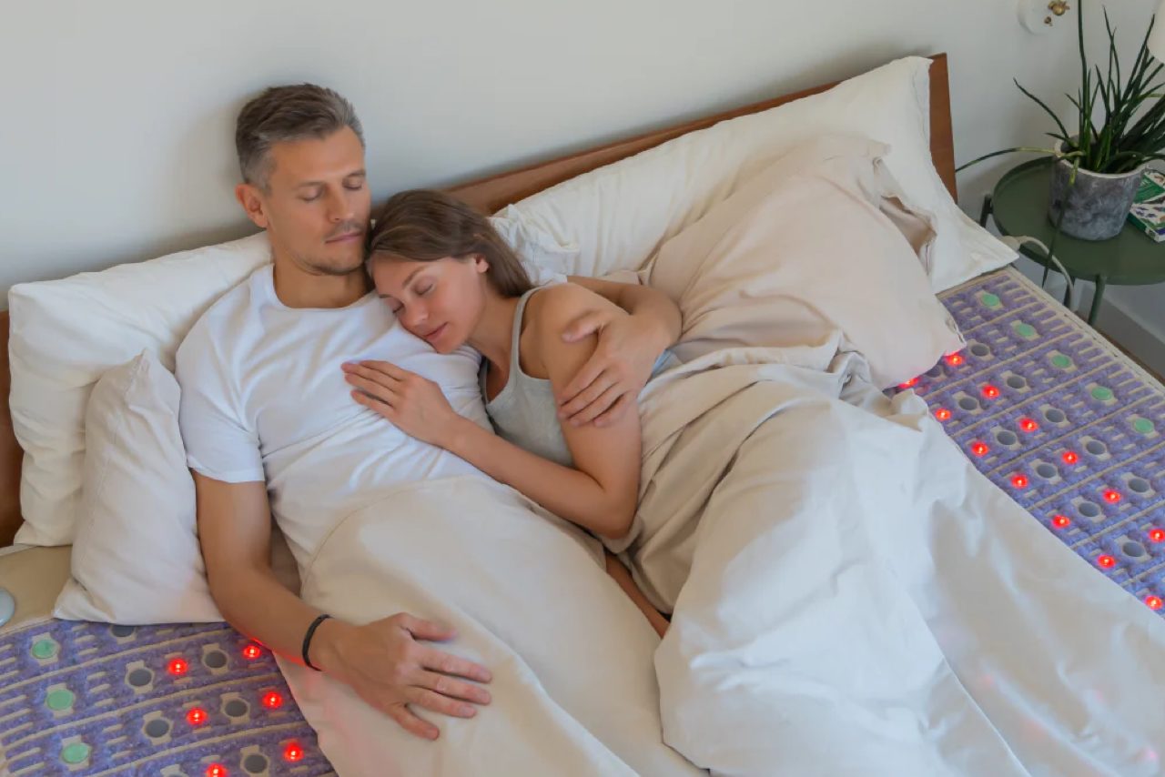 Man and woman sleeping in bed on HealthyLine King TAJ PEMF mat for sleep support Man and woman sleeping in bed on HealthyLine King TAJ PEMF mat for sleep support