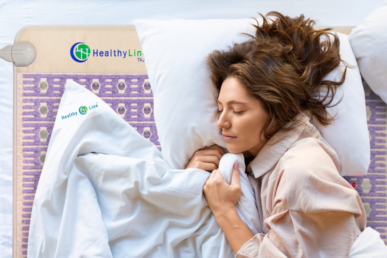 Woman lying in bed using HealthyLine Queen Size TAJ PEMF mat for osteoarthritis relief. Woman lying in bed using HealthyLine Queen Size TAJ PEMF mat for osteoarthritis relief.