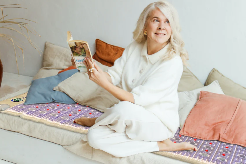 Eldery woman sitting on a Healthyline TAJ mat on sofa