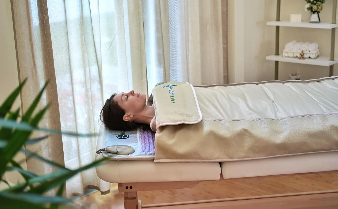 Woman lying down using HealthyLine PEMF Wrap 360 in a clinic for osteoarthritis therapy. Woman lying down using HealthyLine PEMF Wrap 360 in a clinic for osteoarthritis therapy.