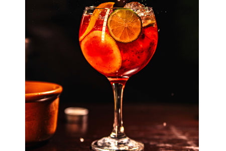 Citrus-Ginger Spritz sauna drink recipe with sparkling water, lemon juice, ginger, ice, and rosemary garnish in a glass