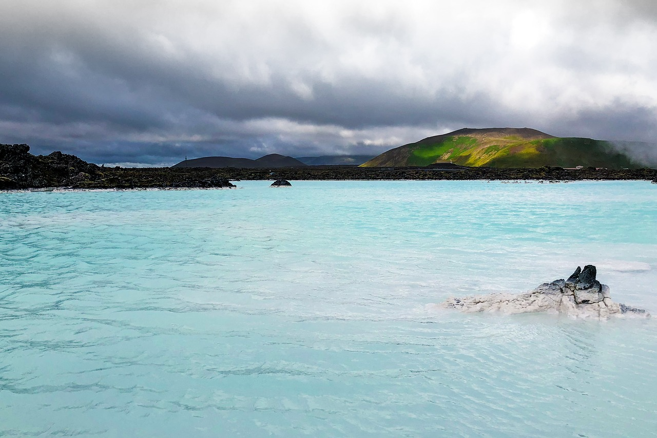 The Blue Lagoon in Iceland, showing the milky blue geothermal waters surrounded by volcanic rock and steam rising into the air The Blue Lagoon in Iceland, showing the milky blue geothermal waters surrounded by volcanic rock and steam rising into the air