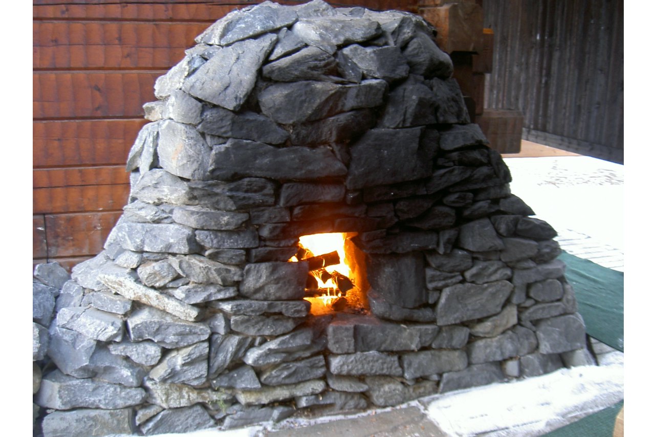 Outdoor Finnish smoke sauna heater, a stone stove with wood inside, generating heat for the sauna. Outdoor Finnish smoke sauna heater, a stone stove with wood inside, generating heat for the sauna.