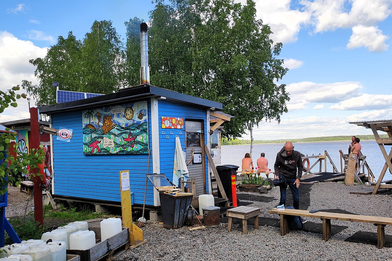 utdoor view of Sompasauna on a lakeside beach in Helsinki, showing a rustic wooden sauna shed with a simple, alternative design. utdoor view of Sompasauna on a lakeside beach in Helsinki, showing a rustic wooden sauna shed with a simple, alternative design.