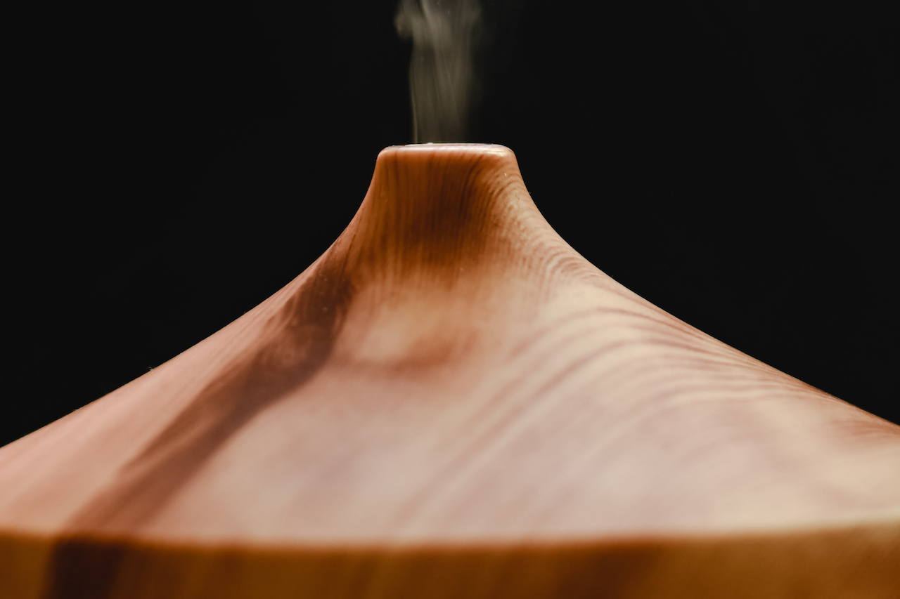 Aromatherapy diffuser releasing vapor during a sauna session to support skin health