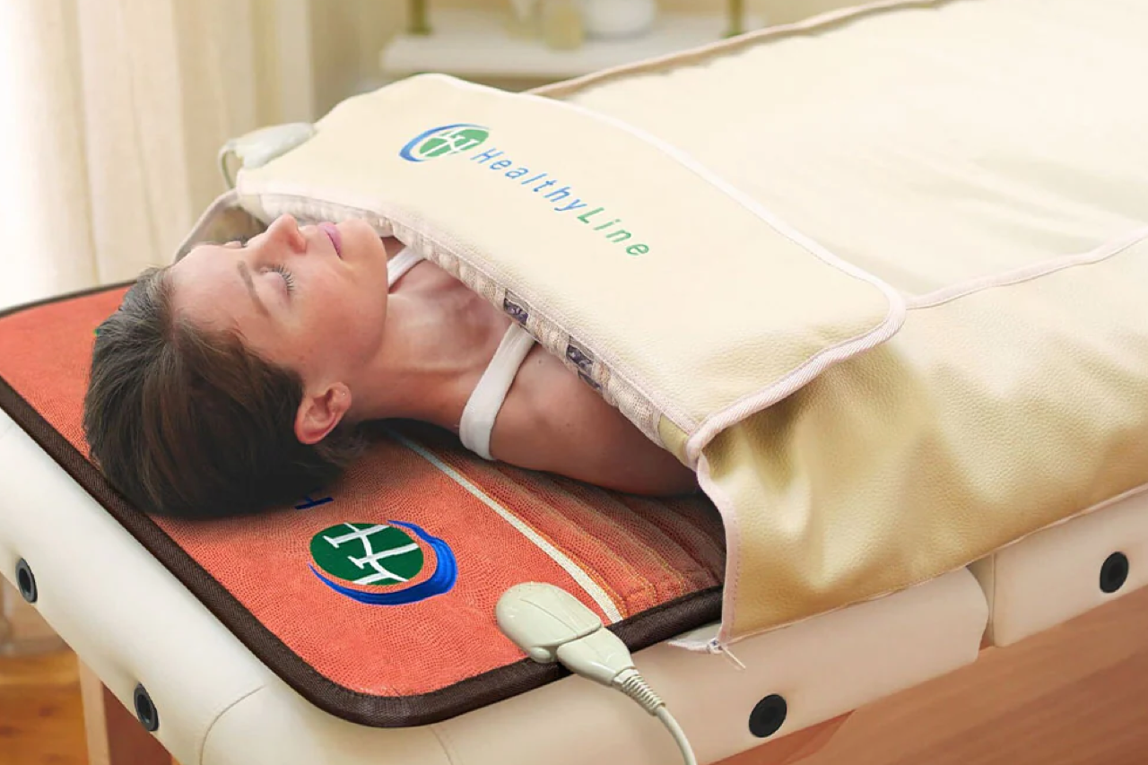 Woman lying in a HealthyLine 360 wrap TAO set in a wellness studio