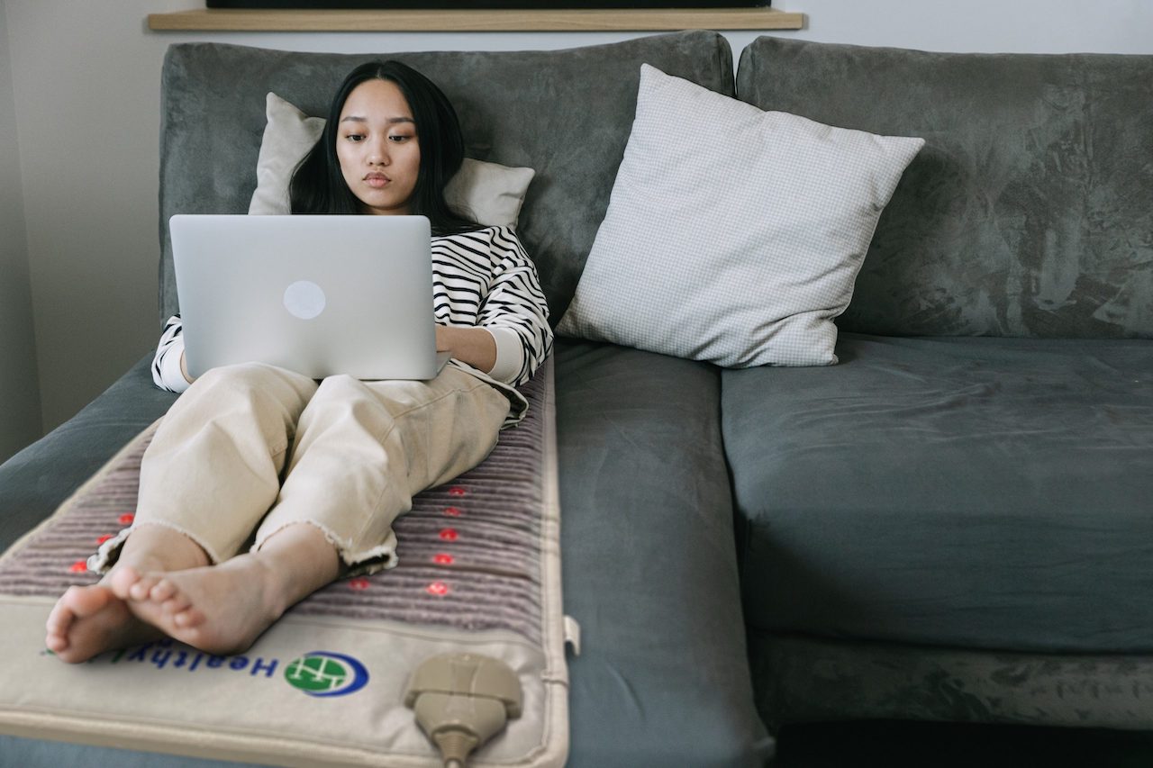 Woman sitting on HealthyLine PEMF mat for back pain relief Woman sitting on HealthyLine PEMF mat for back pain relief